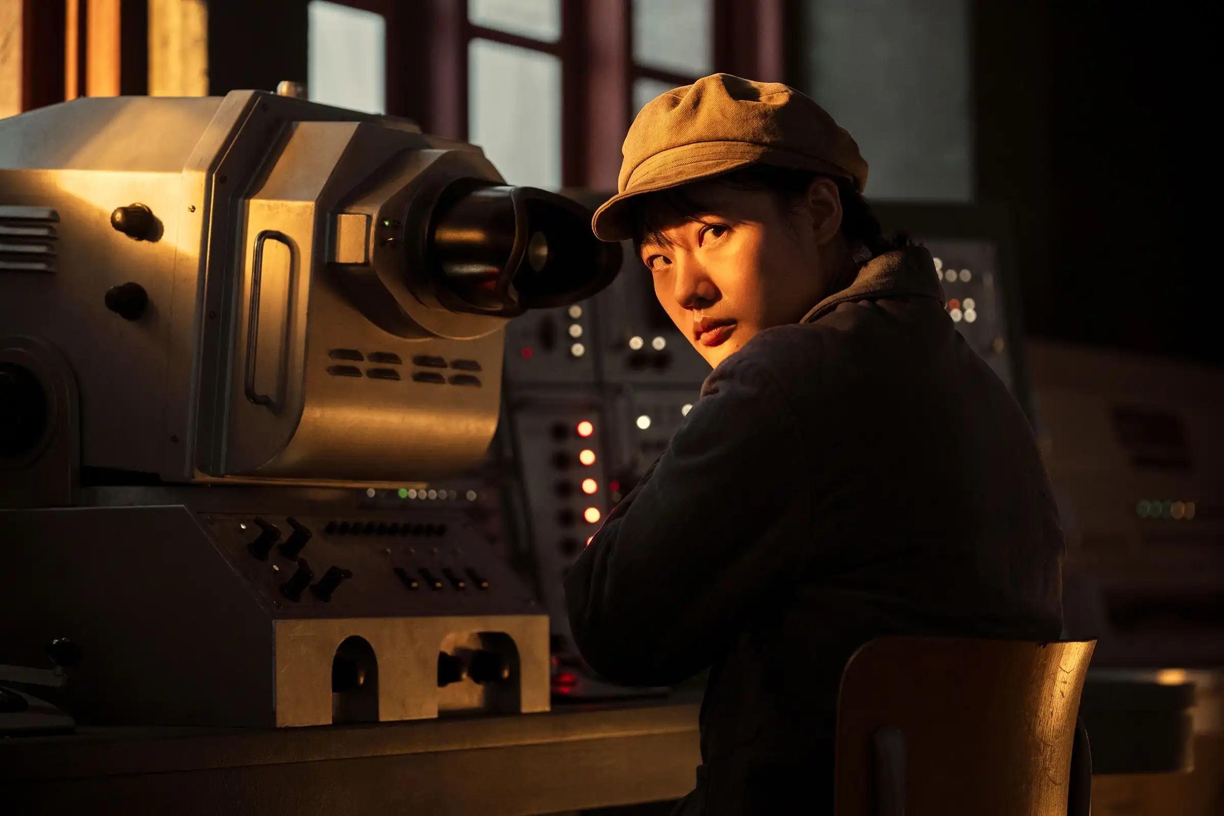 A Chinese scientist looks around before doing something nefarious on a mainframe.