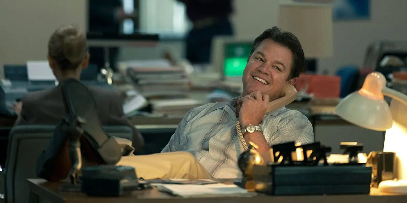 The main character, played by Matt Damon, smiles on the telephone.