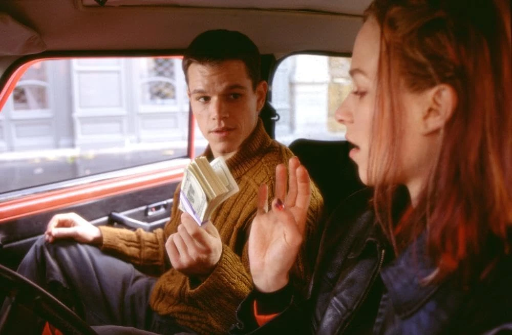 Jason Bourne (Matt Damon) gives money to Marie (Franka Potente).