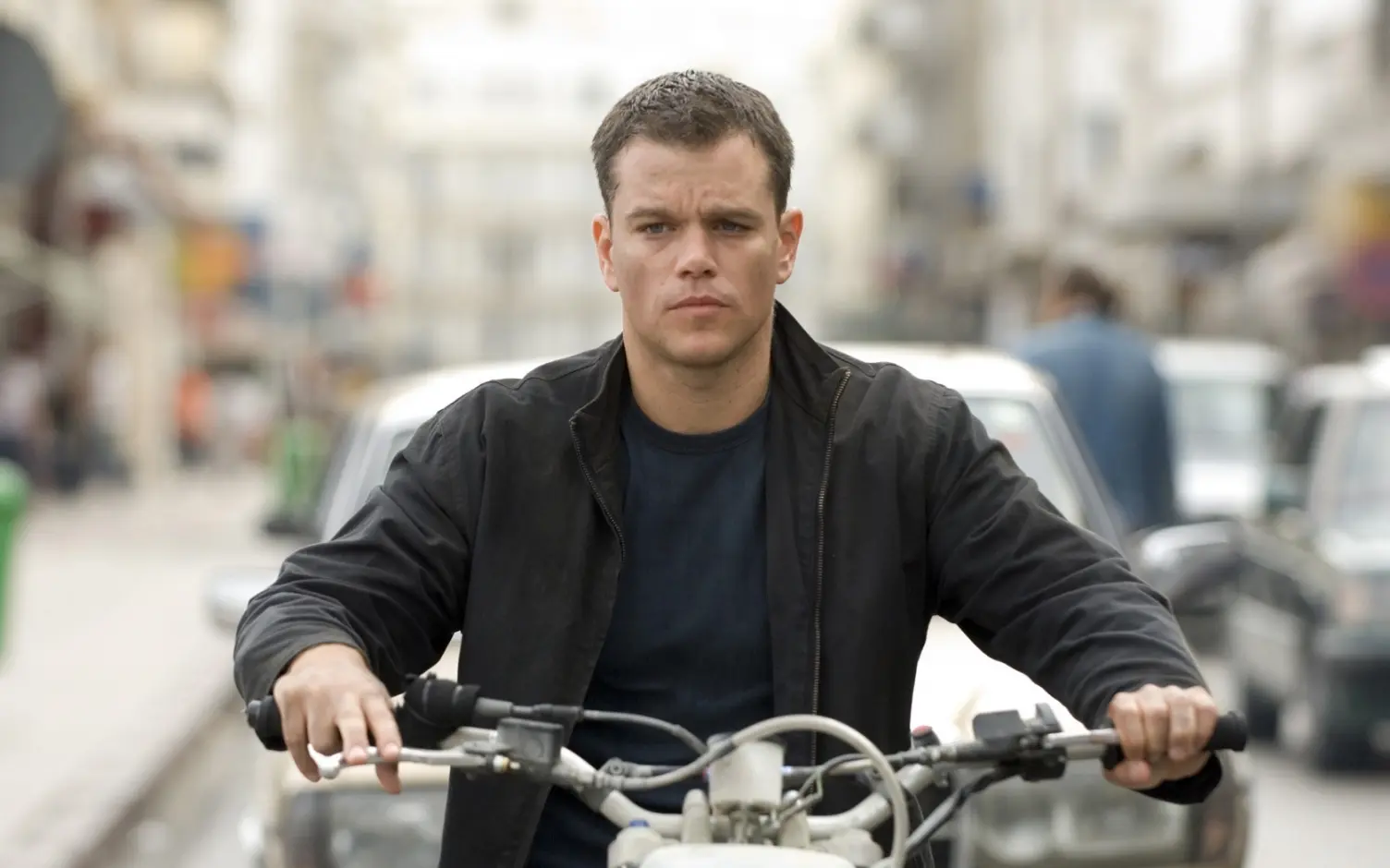 Jason Bourne (Matt Damon) rides a motorcycle in Morrocco.