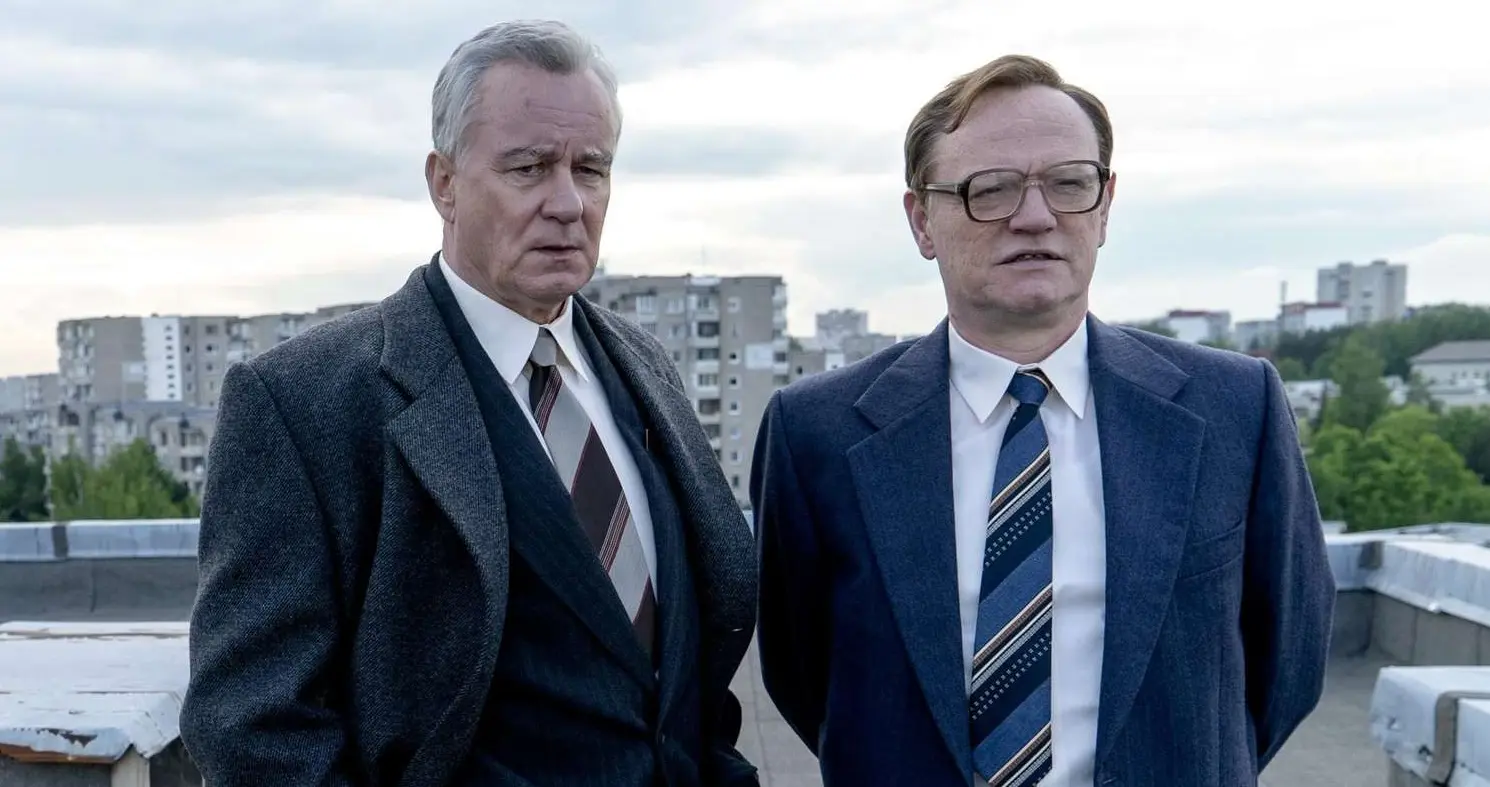 A bureaucrat and a scientist gaze at a blown-up nuclear energy site.