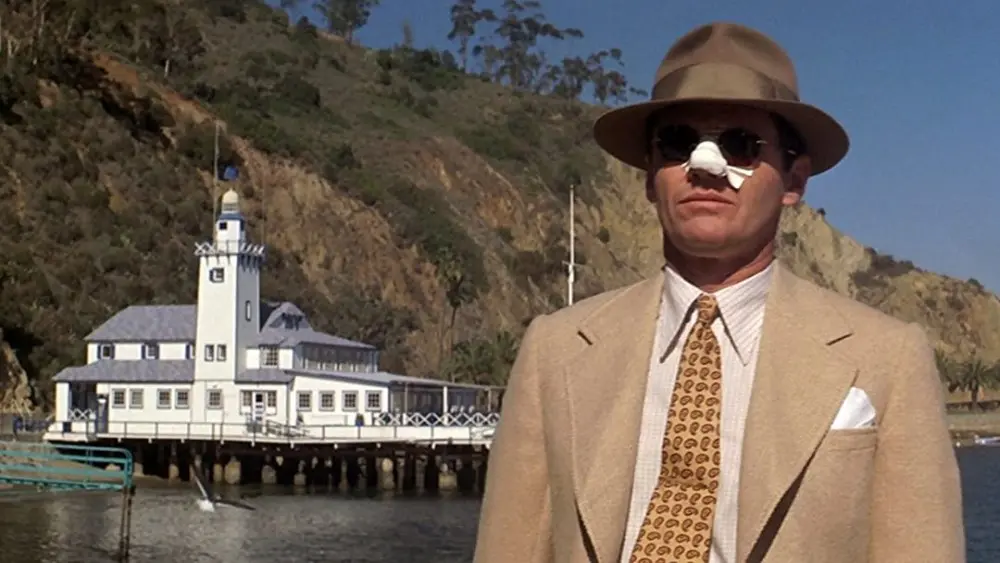 An injured J.J. Gittes (Jack Nicholson) stares into the distance on a boat dock.