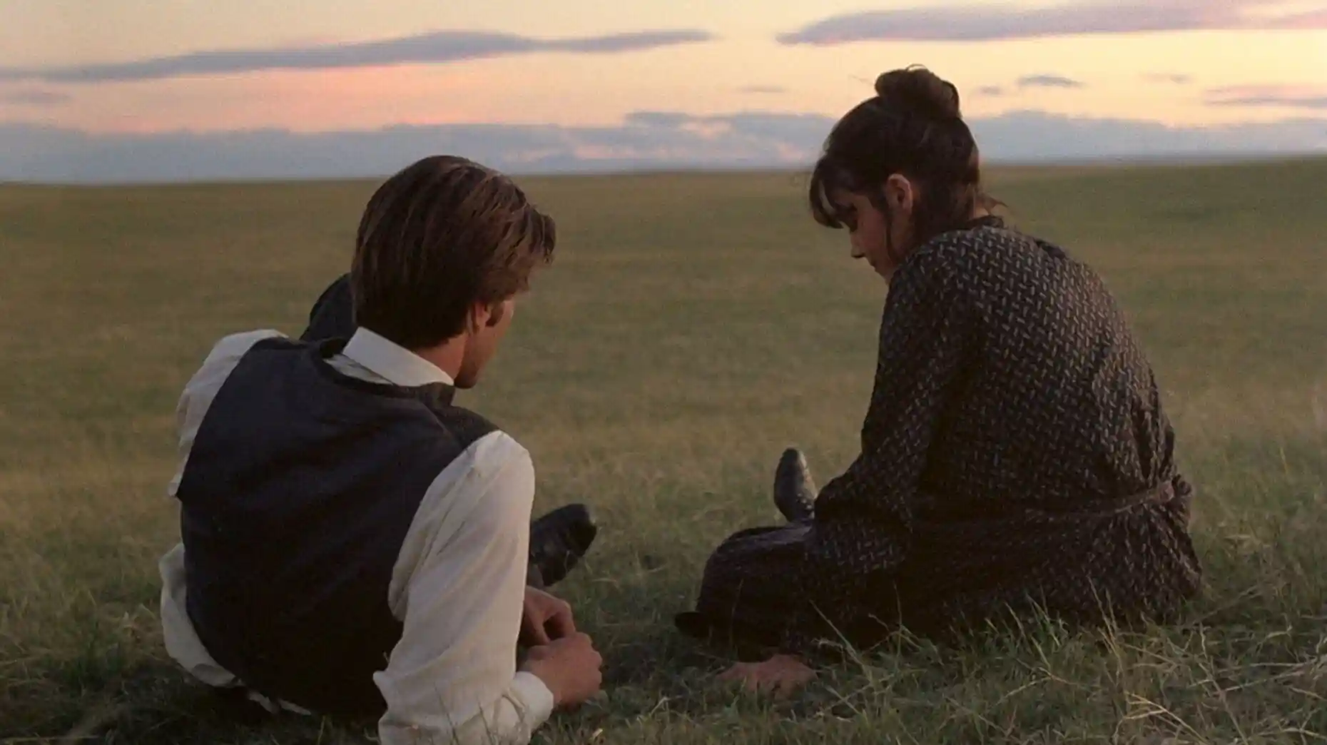 A wealthy land-owner and a poor woman converse on a hill overlooking acres of farmland.