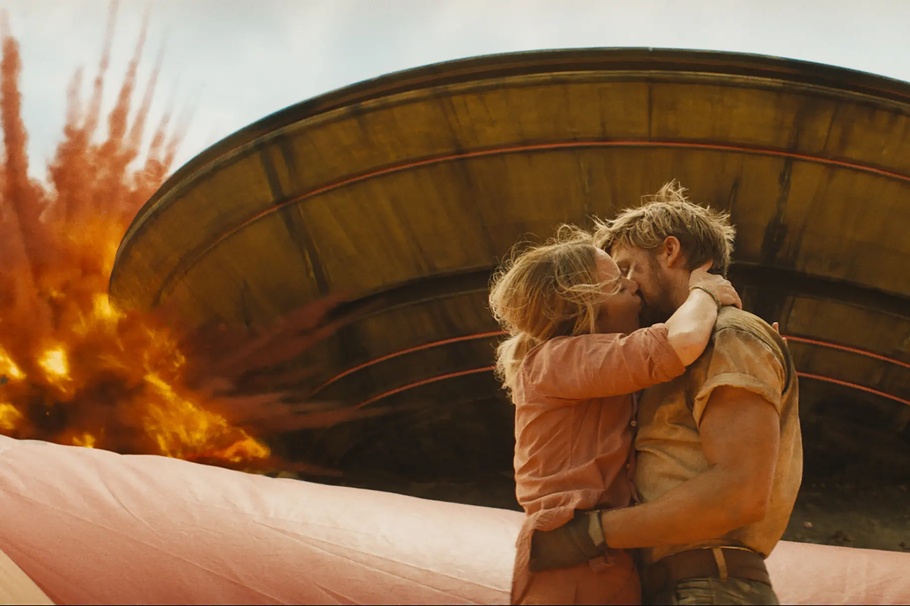 Colt Seavers (Ryan Gosling) and Jodie (Emily Blunt) kiss in front of an explosion.