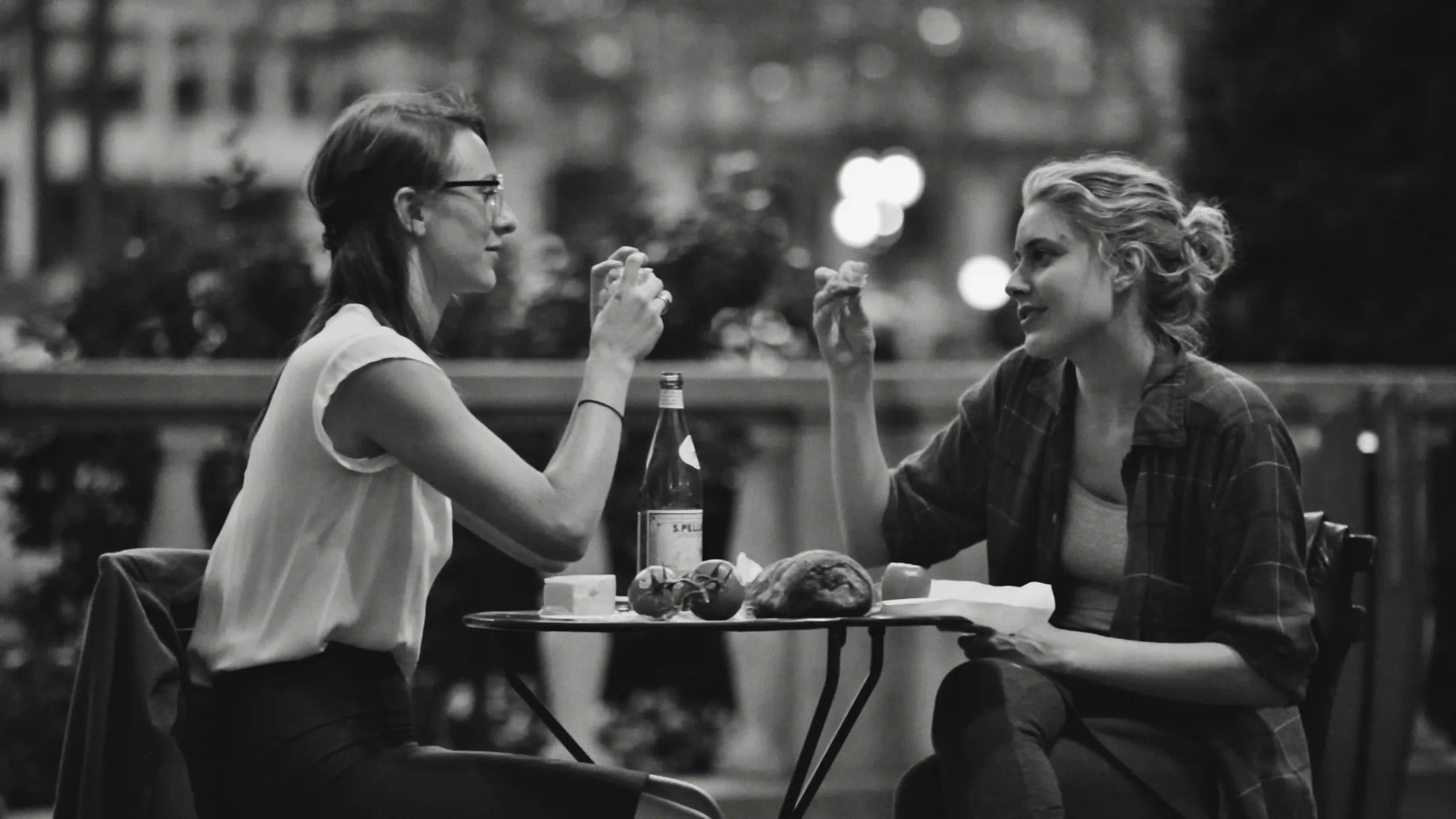 Two friends laugh during a lunch conversation.