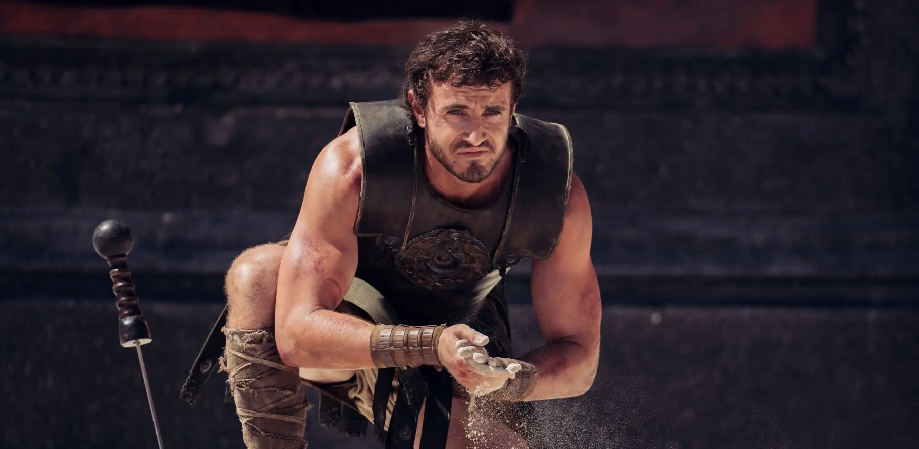 Actor Paul Mescal washes his hands with sand in the Roman Collesium.