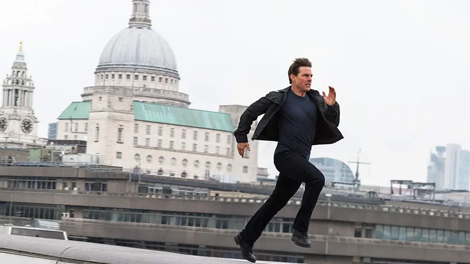 Ethan Hunt (Tom Cruise) runs atop a rooftop in Paris.