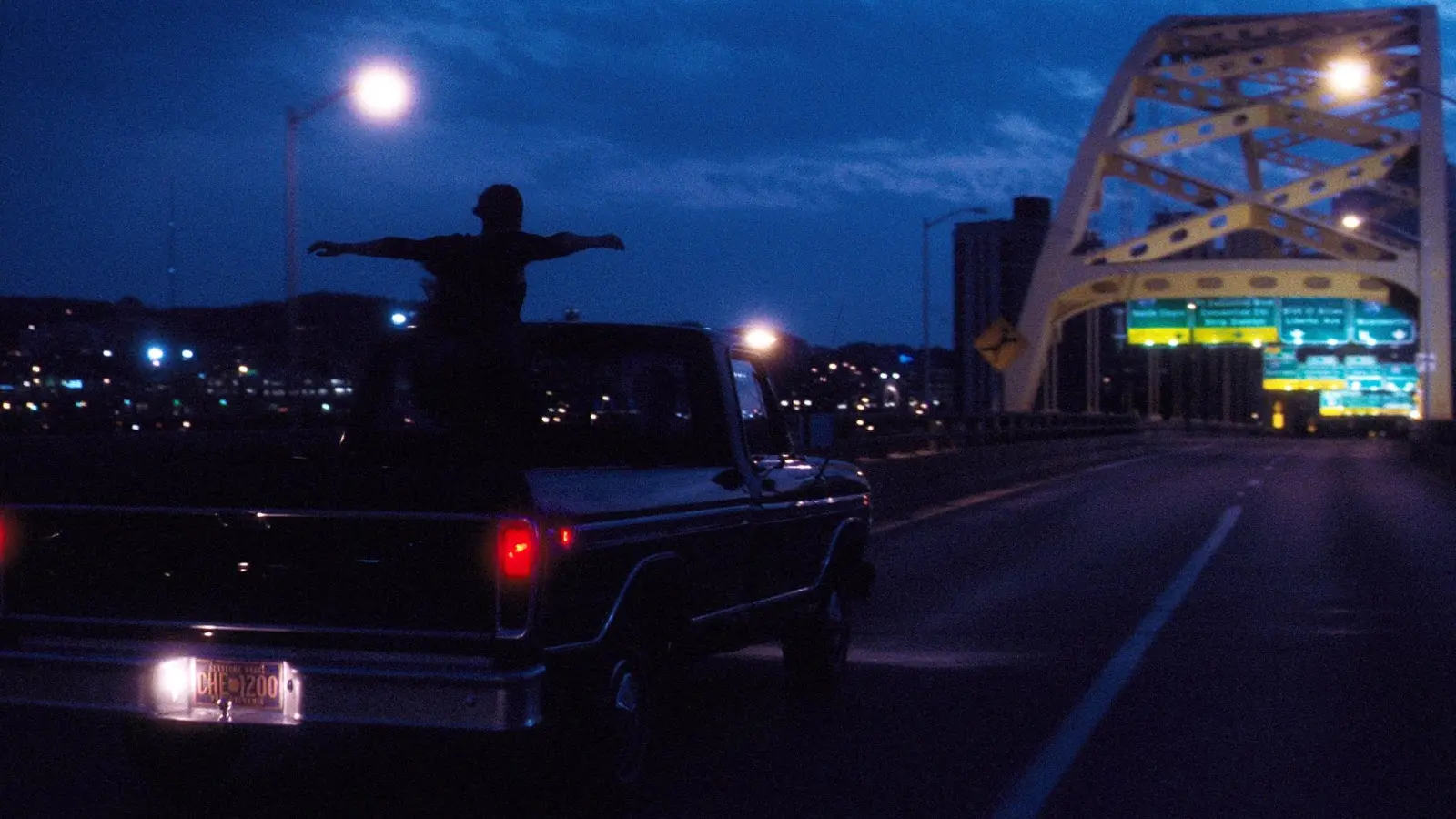 A group of three high school friends drive across the Fort Pitt bridge.