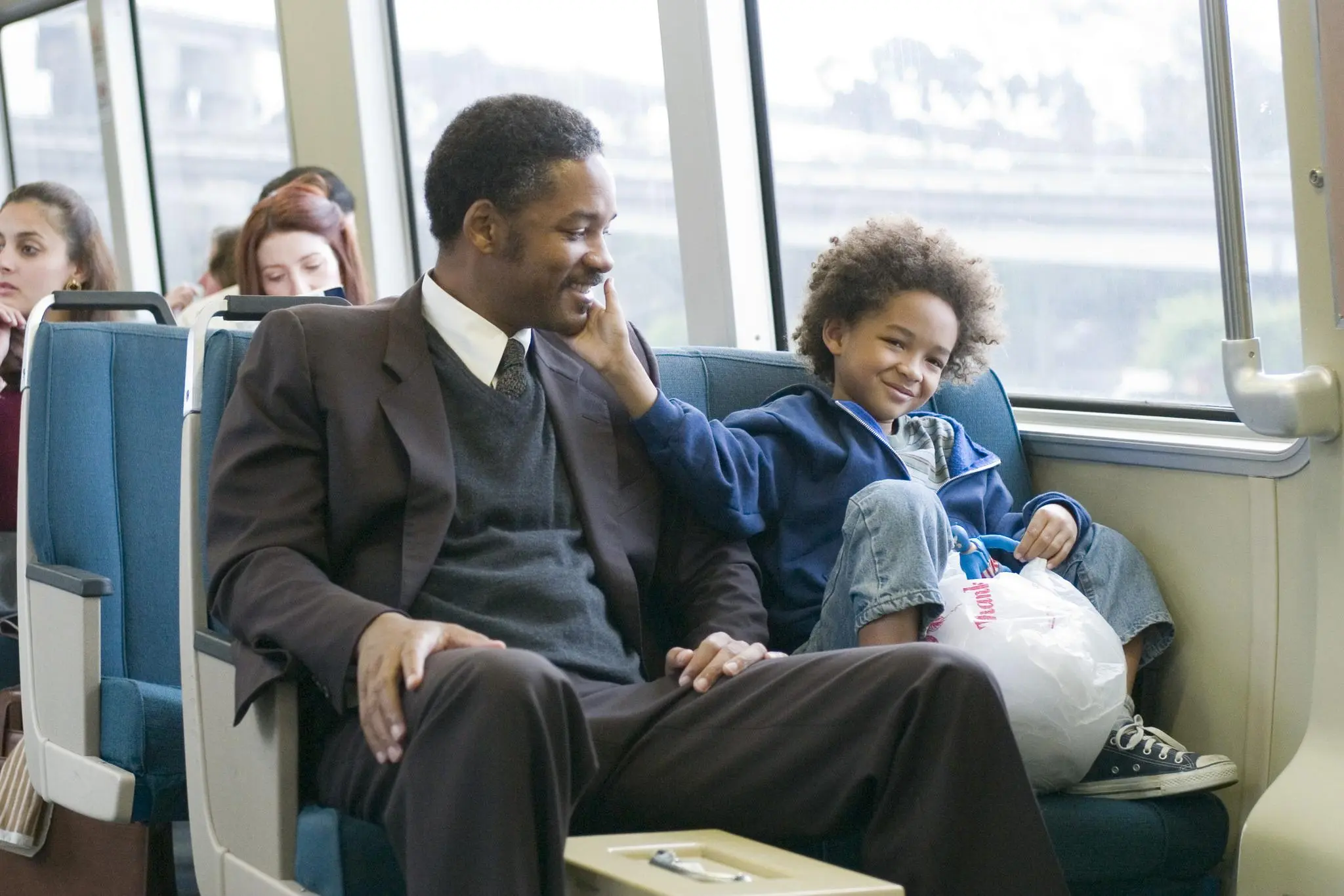 A father and son share a sweet moment on a public subway.