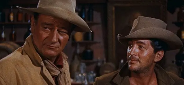 John Wayne and Dean Martin patrol a town in the Wild West.