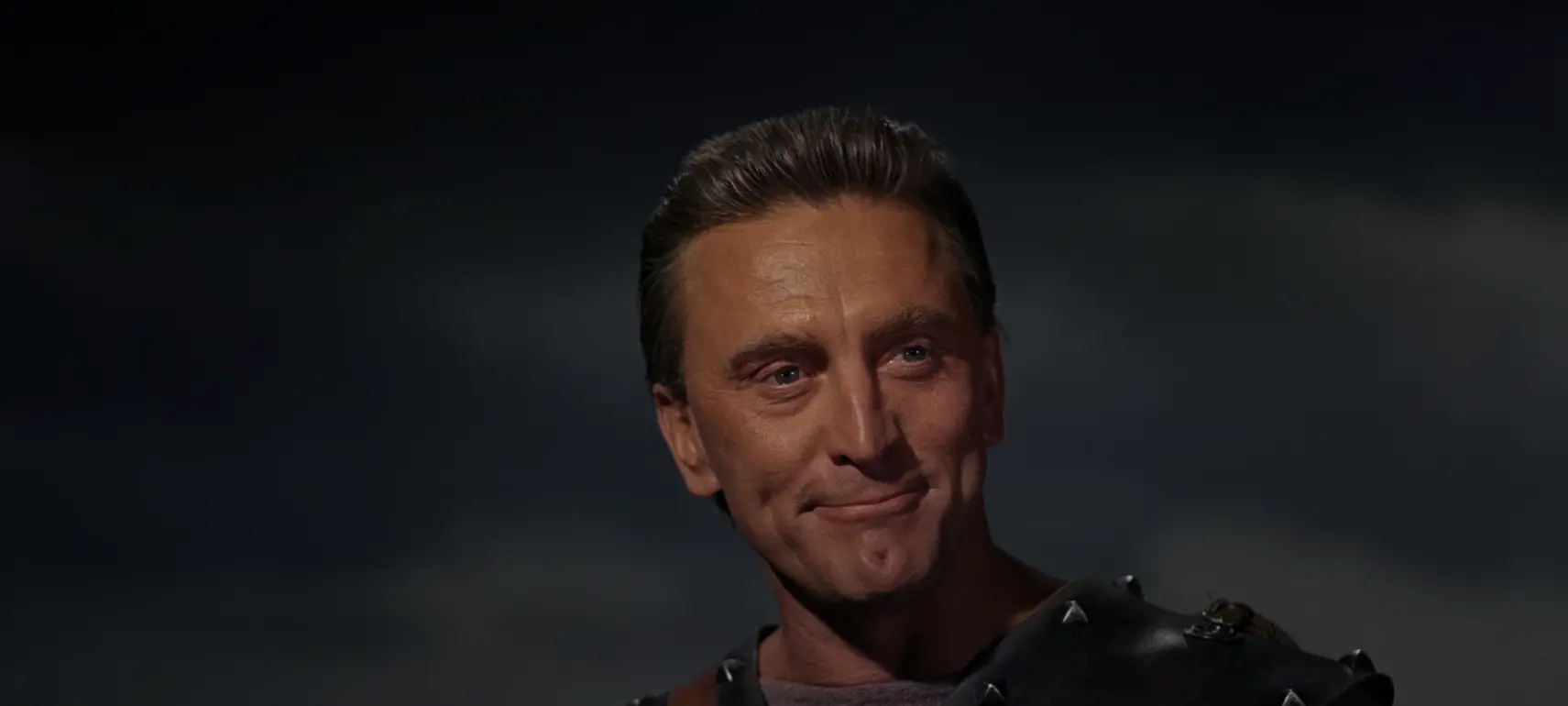 Spartacus (Kirk Douglas) smiles upon fellow warriors.