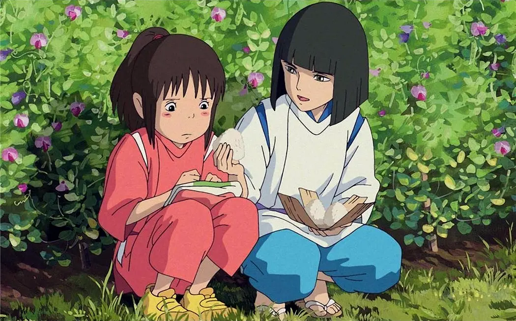 The two main characters sit together in a garden.