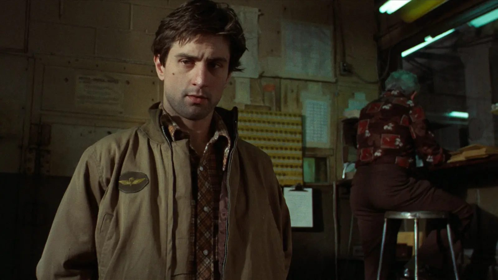 Travis Bickle (Robert DeNiro) looks at his boss.