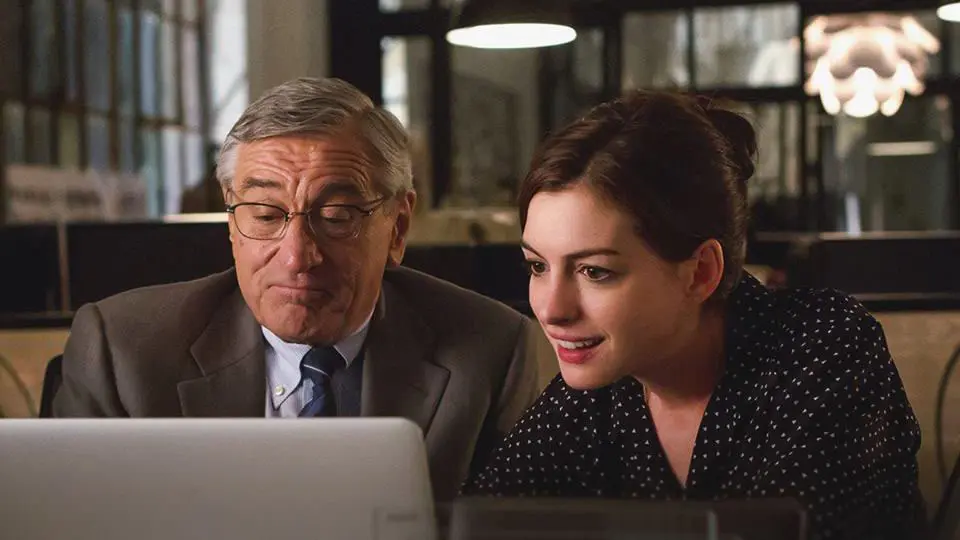 Actors Robert De Niro and Anne Hathaway portray characters who are working late in the office.