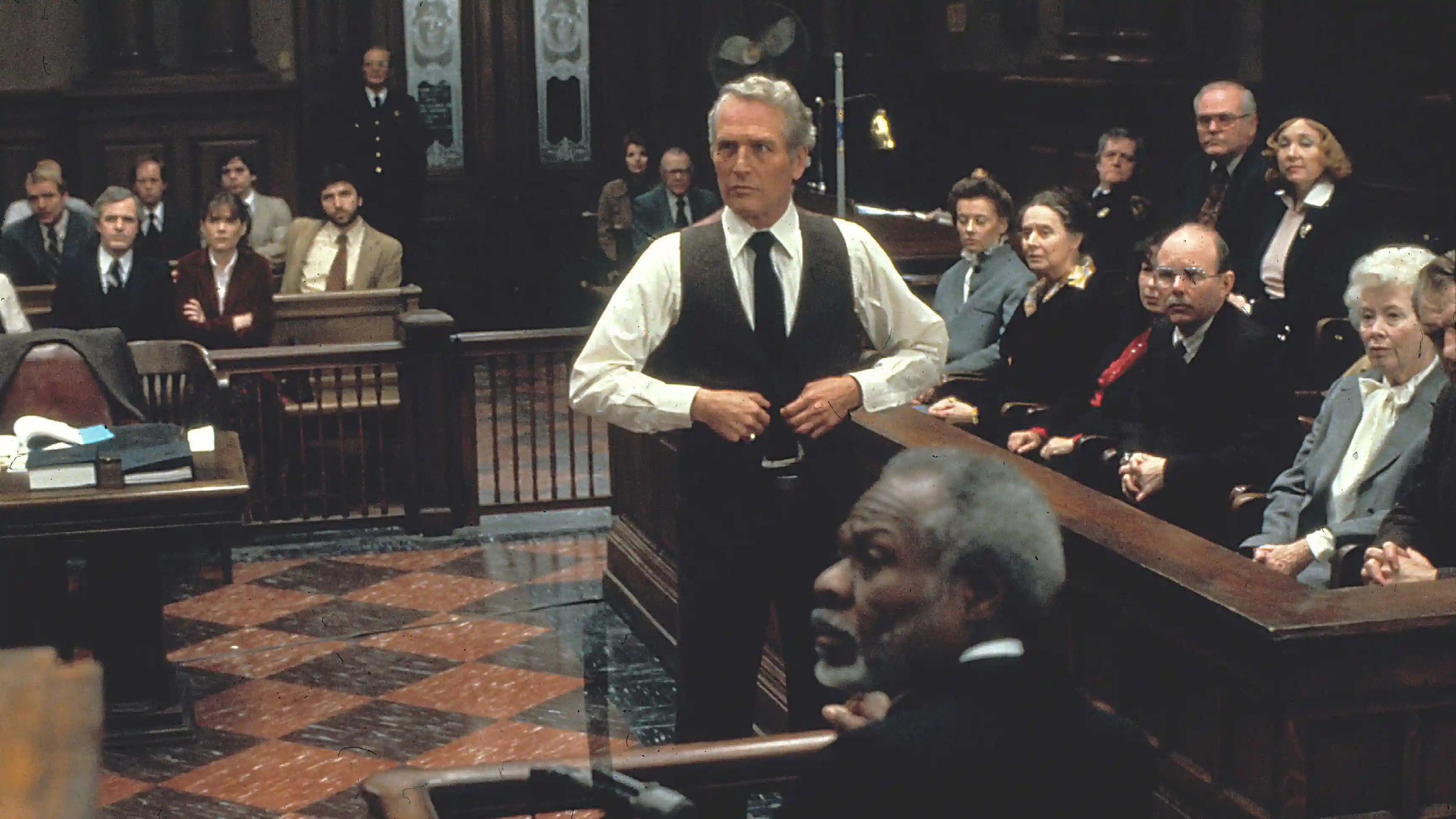 Interviewing a witness, Frank Galvin (Paul Newman) listens to the judge.