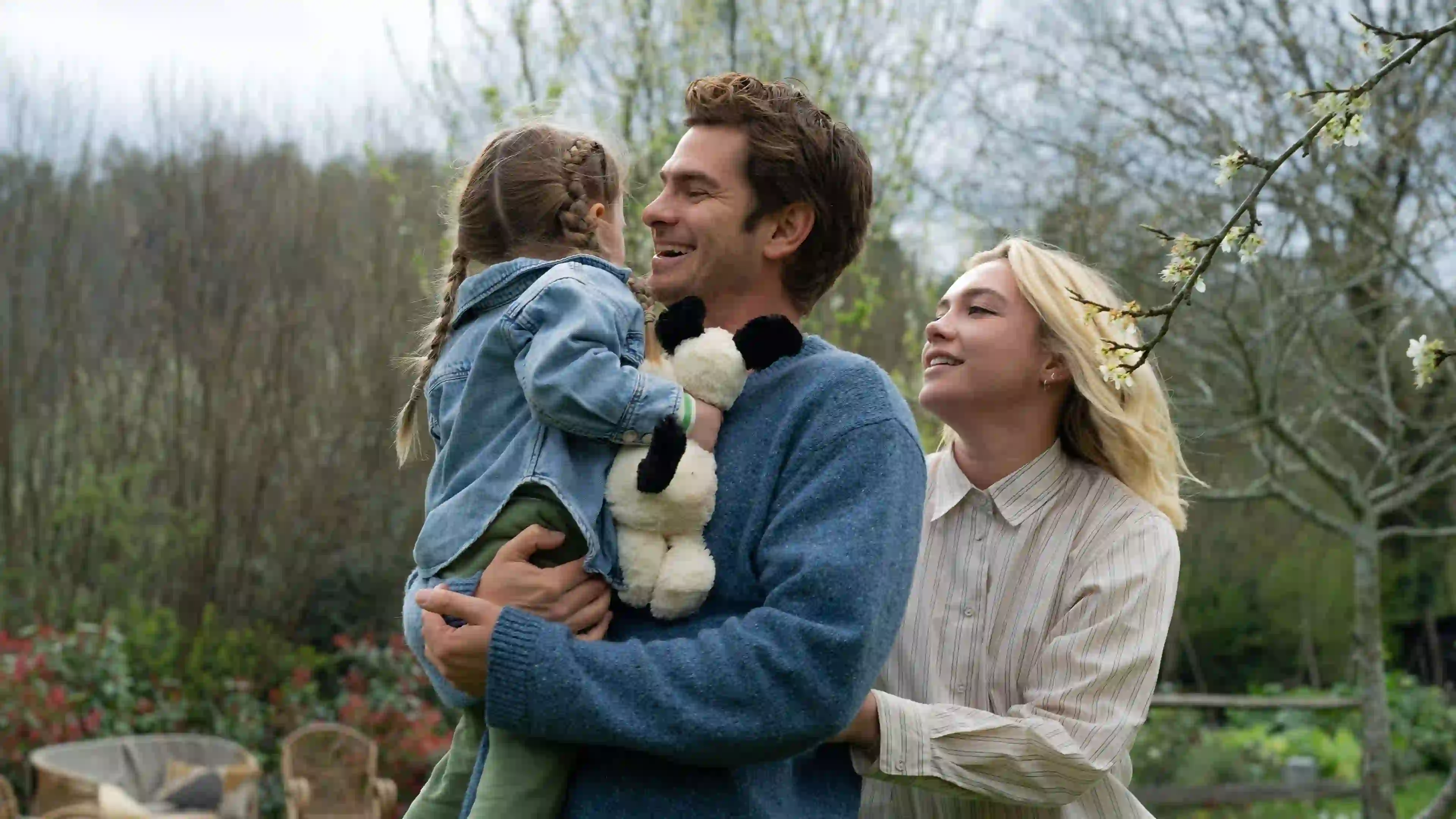 Andrew Garfield and Florence Pugh hug their daughter in the film.