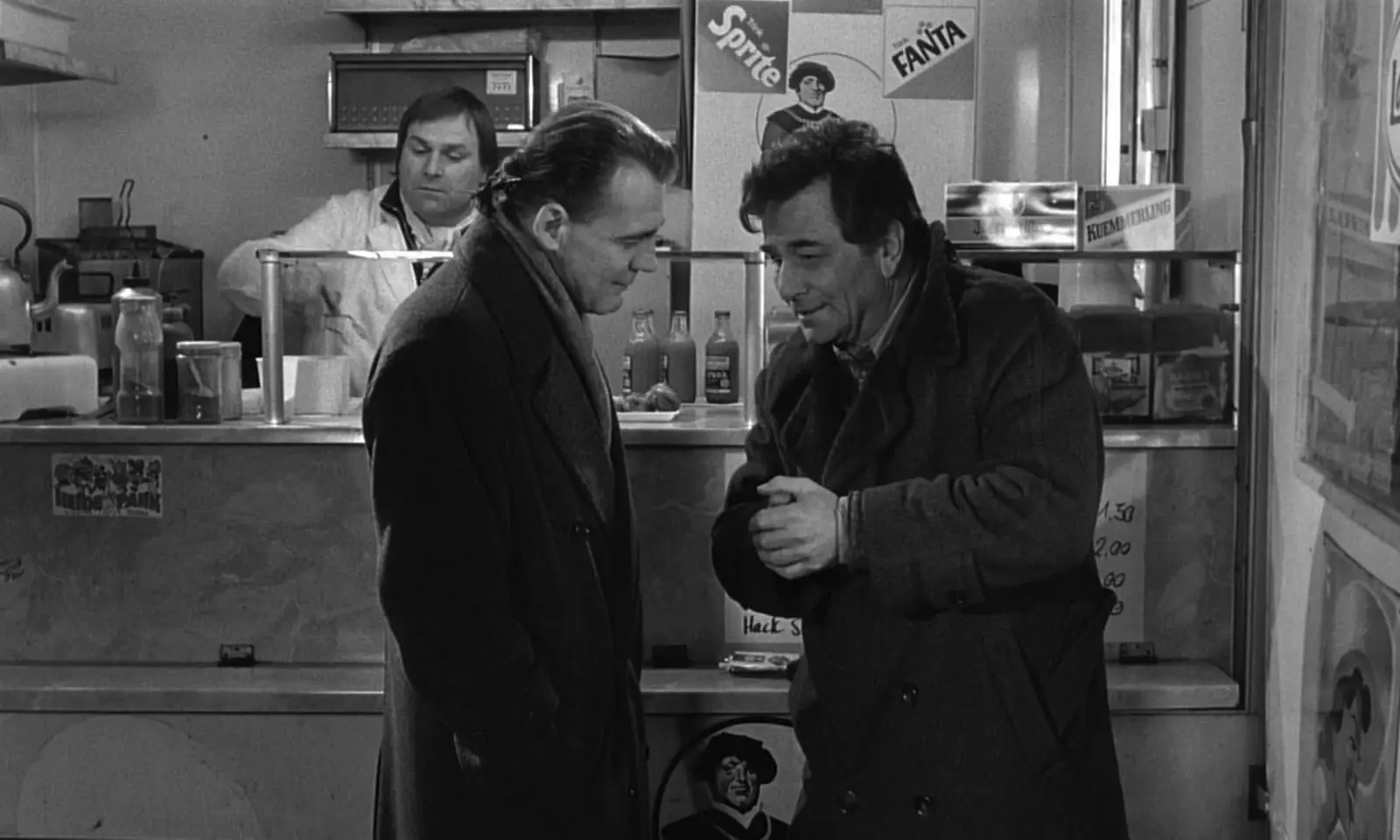 An angel talks to actor Peter Falk at a coffee stand in Berlin.